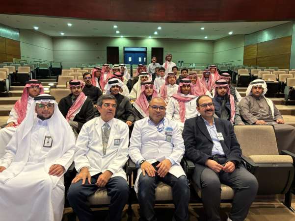 صورة جماعية لأعضاء هيئة التدريس وطلاب المدارس الزائرين في القاعة