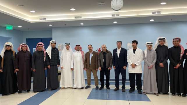 صورة جماعية لأعضاء هيئة التدريس وطلاب المدارس الزائرين في الممر